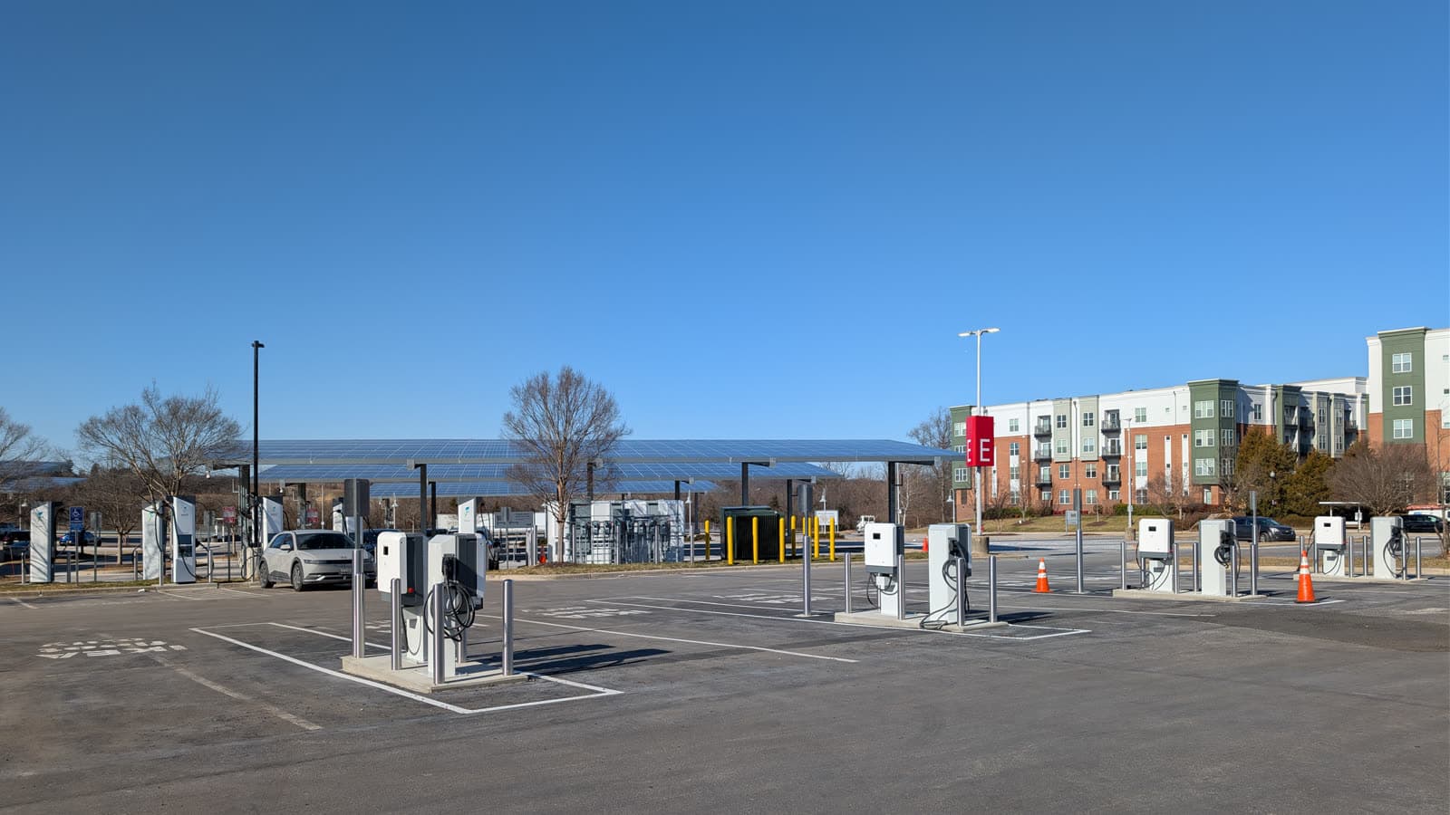 Rangée de bornes de recharge rapide dans un parking public, sous des ombrières photovoltaïques