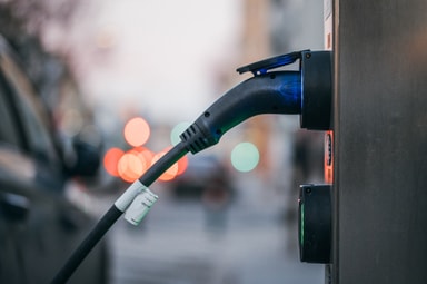Gros plan sur une voiture électrique branchée à une borne de recharge