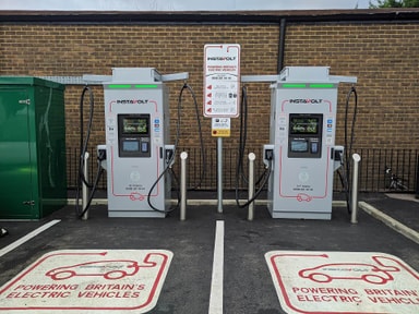 Deux bornes de recharge rapide InstaVolt avec terminal de paiement sans contact sur un parking d'East Grinstead, en Angleterre
