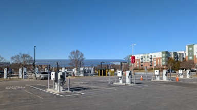 Rangée de bornes de recharge rapide dans un parking public, sous des ombrières photovoltaïques