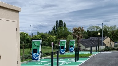Trois bornes de recharge rapide sur une aire de service en bord de route en France